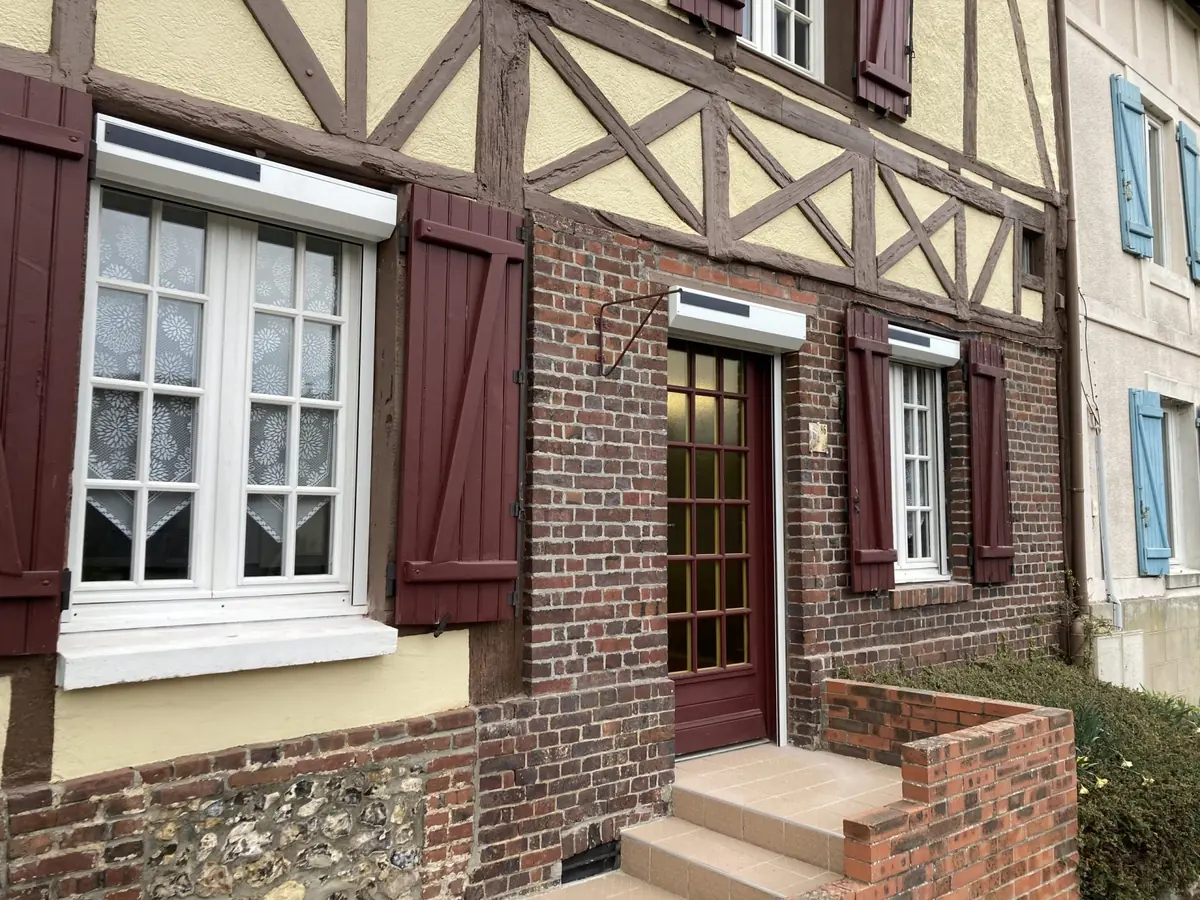 Maison normande à colombages équipée de volets roulants blancs