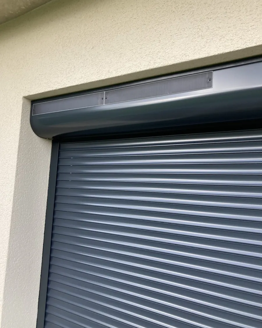 Volet roulant gris anthracite sur une façade enduite